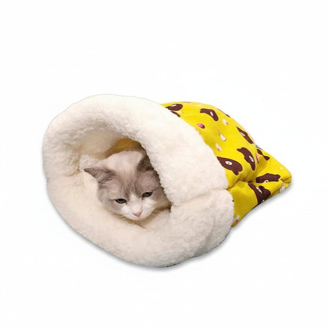 Cat lying in a cozy white pet bed with a yellow blanket featuring brown bears.